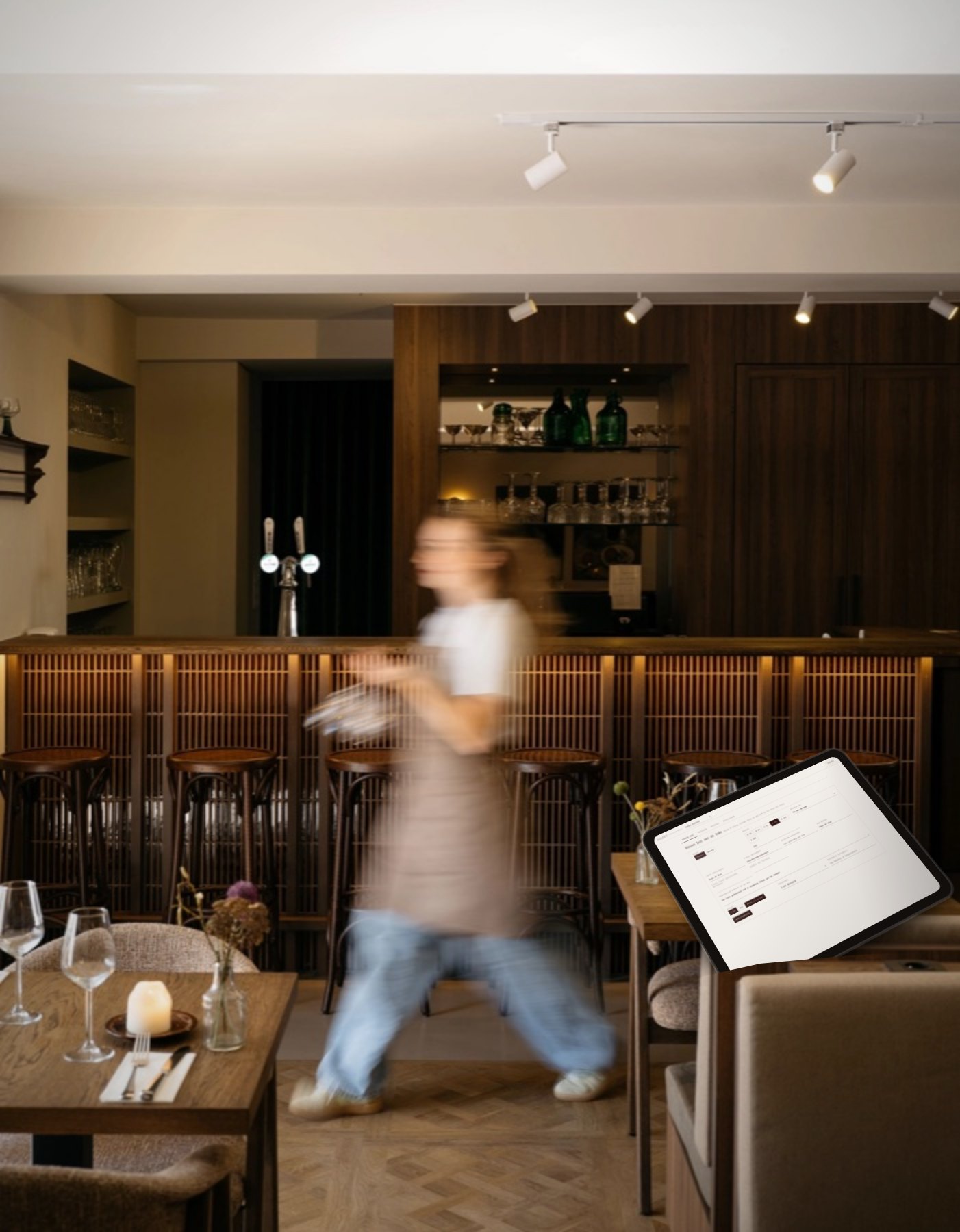 De bar van Blanckthys met een tablet waarop het baliescherm van Voucello openstaat, terwijl een medewerker voorbijloopt